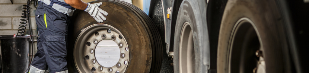 Heavy duty truck tires being rolled onto a truck